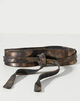 Worn leather belt on a light gray background