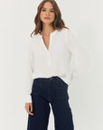 Woman wearing a white blouse and dark blue jeans on a white background