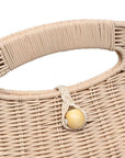 Close-up of a woven handbag handle with a wooden ball accent on a white background
