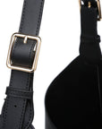 Black leather bag with gold buckle on a white background