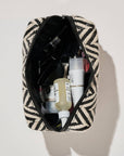 Patterned toiletry bag with personal care items on a light background