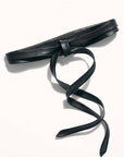 Black leather belt with a decorative knot on a white background