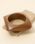 Wooden bowl on a stone surface with a beige background