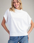 Woman wearing a white top and blue jeans on a gray background
