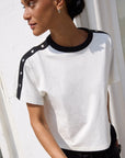 Woman wearing a white t-shirt with black accents against a white background