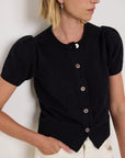 Woman wearing a black short-sleeve cardigan with buttons against a white background