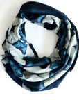 Navy and white patterned infinity scarf on a white background