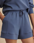 Person wearing a blue tracksuit on a beige background