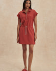 Woman wearing a red dress against a beige background