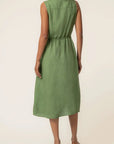 Person wearing a green dress on a beige background