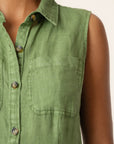 Green sleeveless shirt worn by a person on a beige background