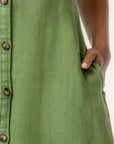 Green dress with button details on a white background