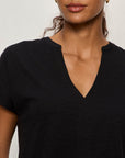 Woman wearing a black V-neck t-shirt against a plain background