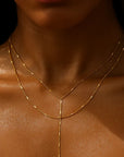 Gold necklace on a person's neck with a blurred background
