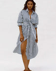 Woman wearing a black and white striped dress on a white background
