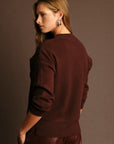 Woman wearing a brown outfit against a matching background