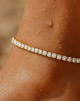 Gold bracelet with diamonds on a wrist with water droplets
