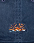 Navy blue cap with an embroidered logo featuring a sun and wave design.