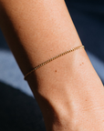 Gold bracelet on a wrist with a blurred background