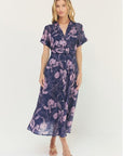 Woman wearing a purple floral dress on a white background