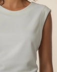 Light gray sleeveless top worn by a person on a beige background