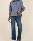 Person wearing a blue shirt and jeans on a beige background