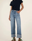 Person wearing a navy t-shirt and blue jeans on a plain background