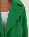Green coat with a neutral background