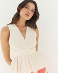 Woman wearing a white dress with a coral skirt on a white background