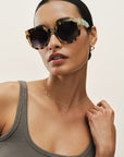 Woman wearing stylish sunglasses with a neutral background