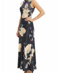 A sleeveless high-neck maxi dress with a dark navy base and a large abstract floral print in cream, beige, and purple, modeled against a plain white background.