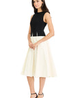 Woman wearing a black top and white skirt on a white background