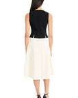 Woman wearing a black top and white skirt on a white background