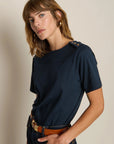 Woman wearing a navy blue t-shirt with a beige background