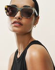 Woman wearing sunglasses with a neutral background
