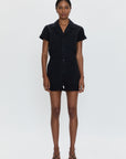 Person wearing a black romper on a white background