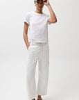 Person wearing a white t-shirt, white pants, and a green cap on a white background