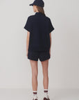 Person wearing a navy outfit with a cap on a white background
