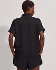 Person wearing a black outfit on a plain background