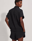 Person wearing a black outfit against a white background