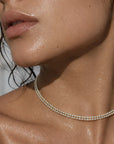 Close-up of a woman wearing a delicate necklace with a blurred background