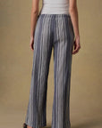 Person wearing blue and white striped pants on a beige background