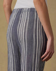 Striped pants worn by a person on a beige background