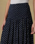 Navy patterned skirt worn by a person on a beige background