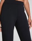 Black high-waisted leggings worn by a person on a gray background