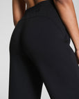 Black high-waisted pants worn by a person on a light gray background