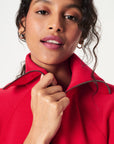 Woman wearing a red jacket with a neutral background