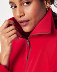 Woman wearing a red jacket with a neutral background