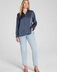 Woman wearing a navy shirt and light blue jeans on a white background