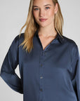 Woman wearing a navy blue shirt against a plain background